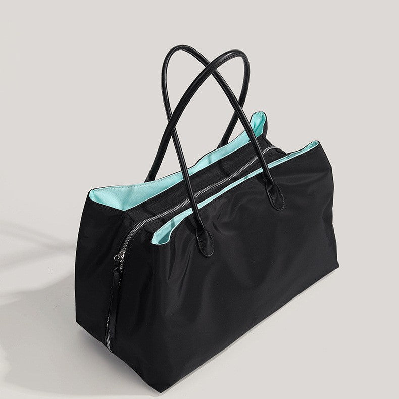 Un sac ordinateur femme noir à doublure turquoise