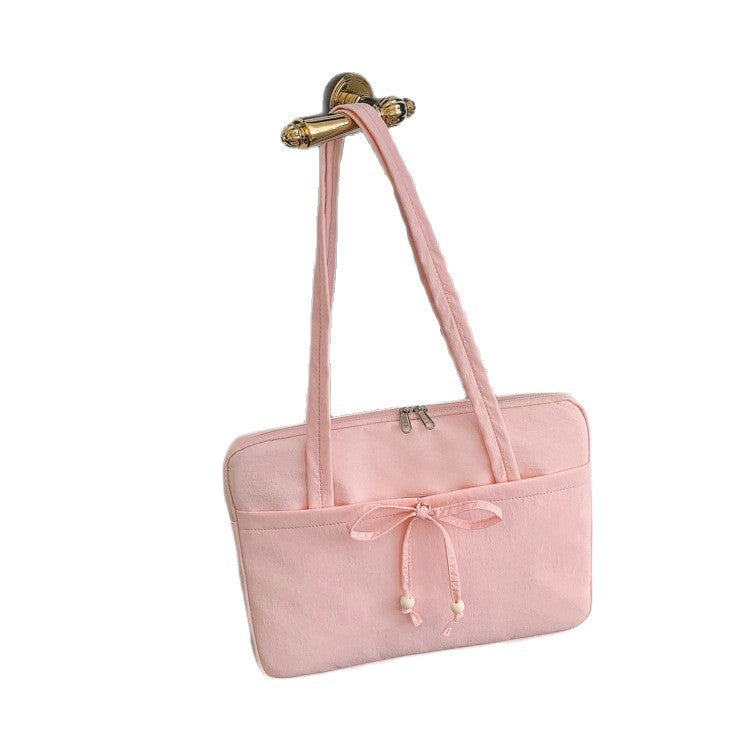 Un sac ordinateur femme orné d'un nœud à perles